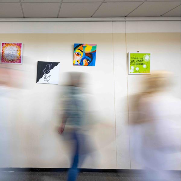 Langzeitbelichtung mit Menschen vor einer Wand mit Bildern
